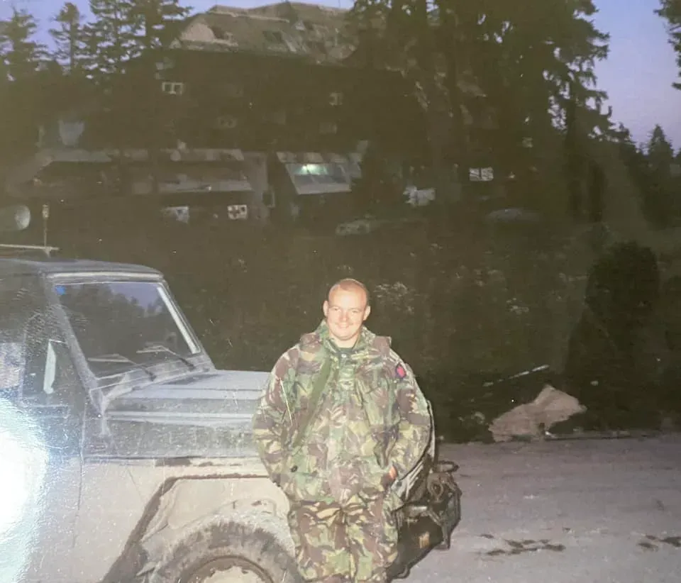 A soldier stands before the ruined Hotel Igman in 1995